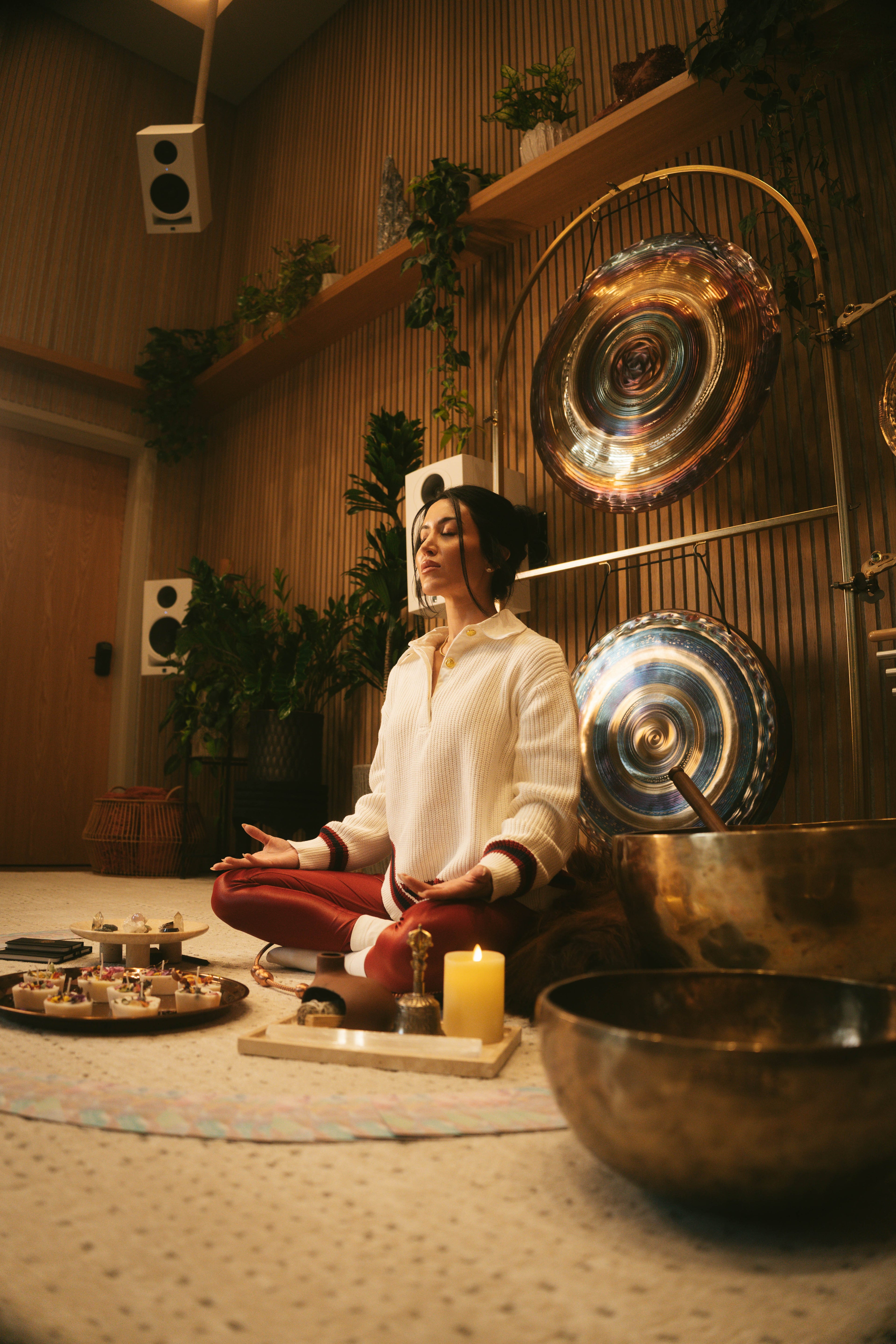 A guest meditating in the Sacred Society sanctuary in Denver, gongs and singing bowls beside her